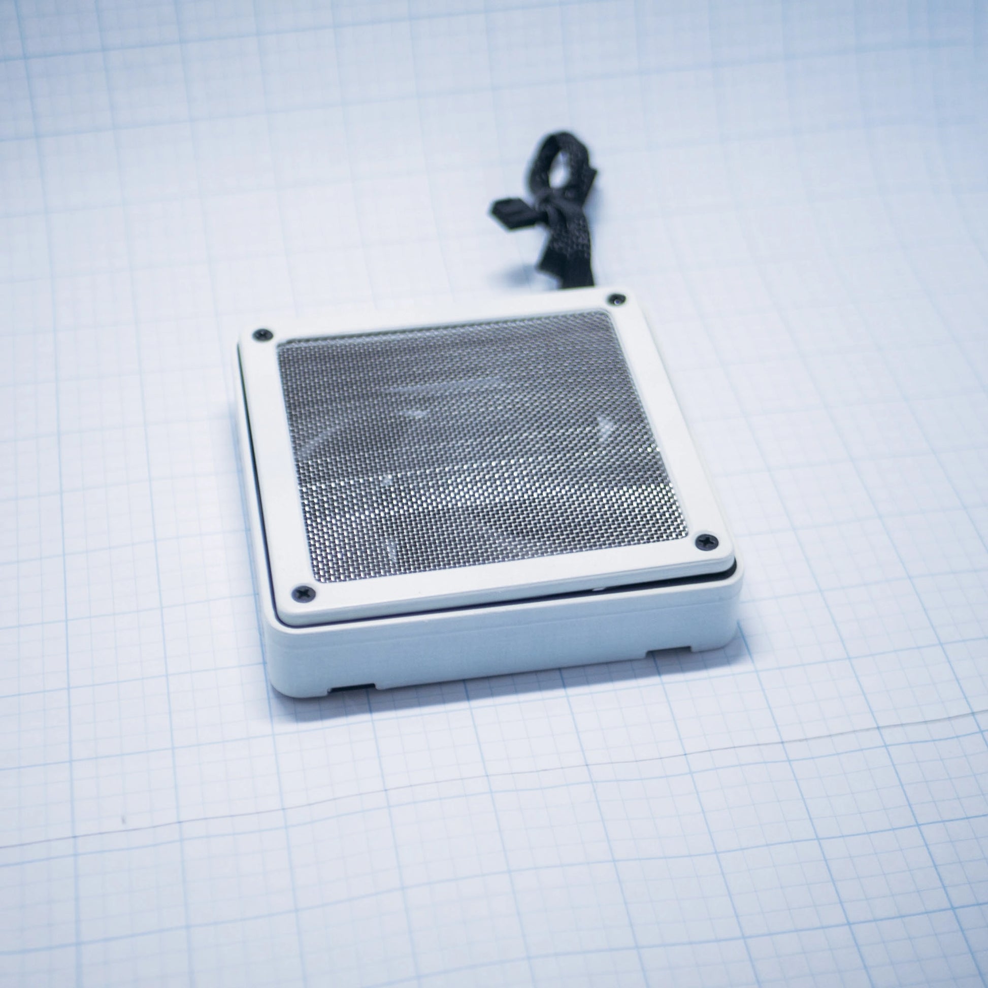 White shell with raw steel mesh - 120mm Fan Shroud Filter & Outer Cover lying flat against white background with grid pattern. 